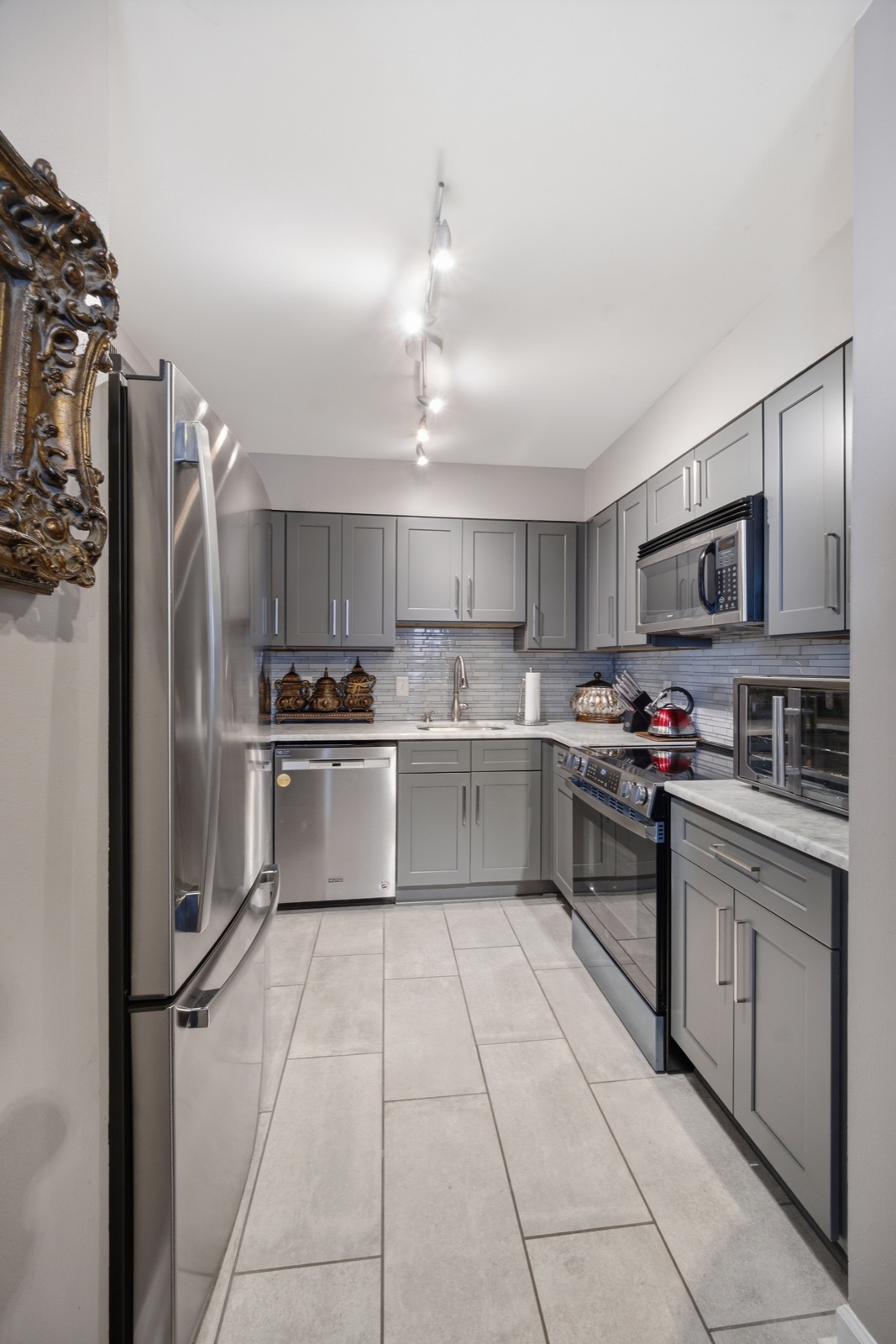 Updated kitchen with gray shaker cabinets and stainless appliances
